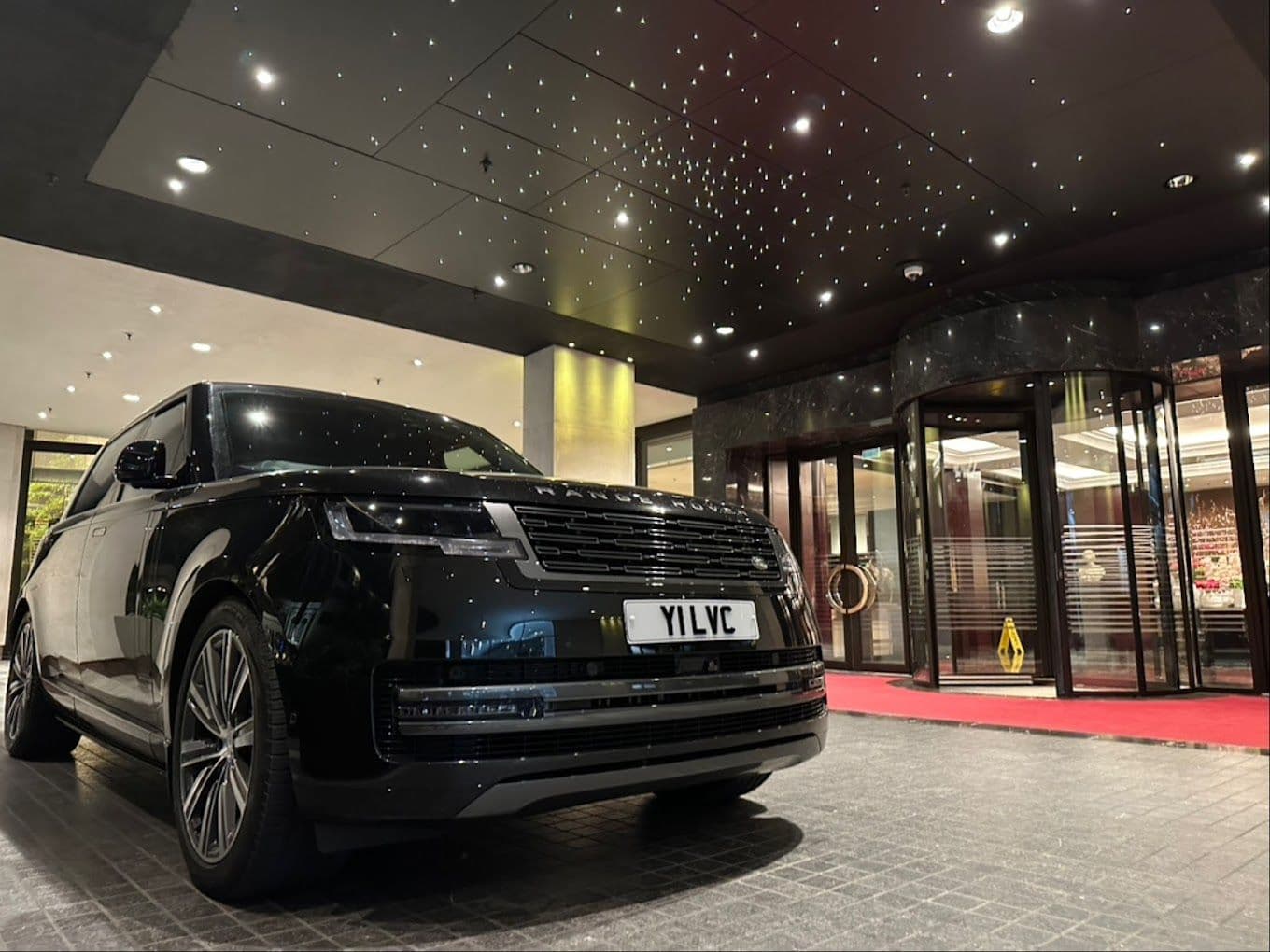 Private chauffeur car waiting outside a luxury hotel for transfer to the private jet terminal