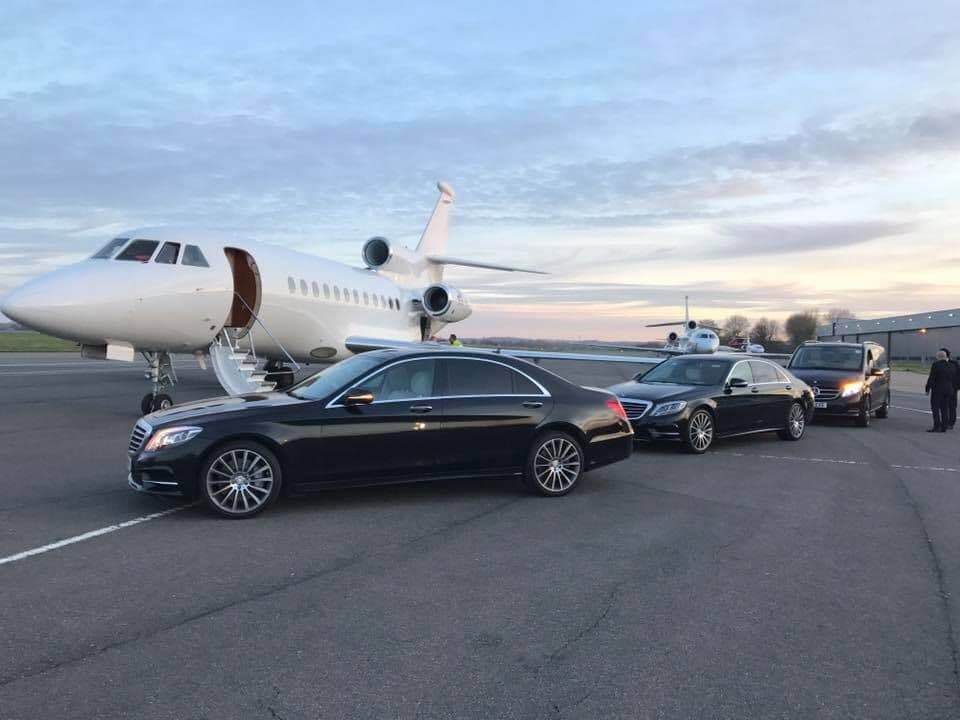 Concierge chauffeur service with luxury car waiting for clients at a private jet terminal in London