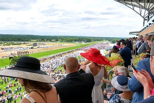 Guests in elegant housecoats enjoy a morning of champagne and conversation while watching the races from the balcony.