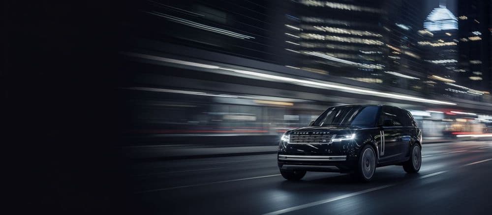 Black Range Rover driving on an open road, representing executive travel and luxury transport