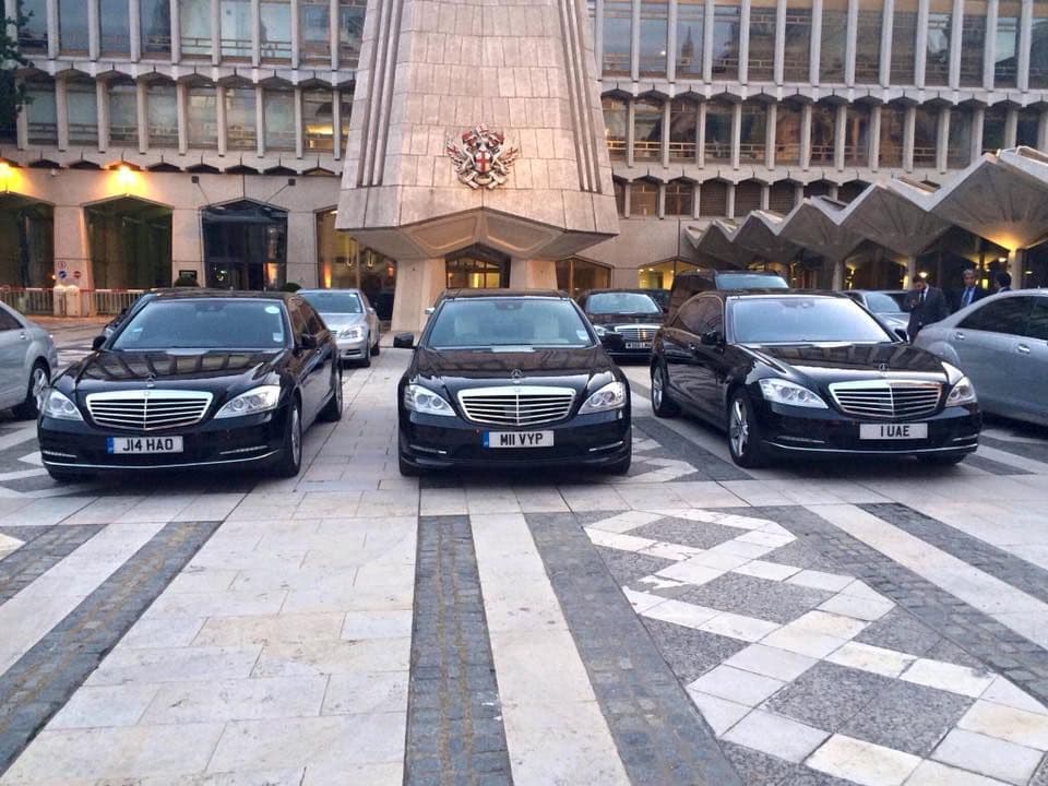 Luxury chauffeur-driven car parked at a red carpet VIP event.