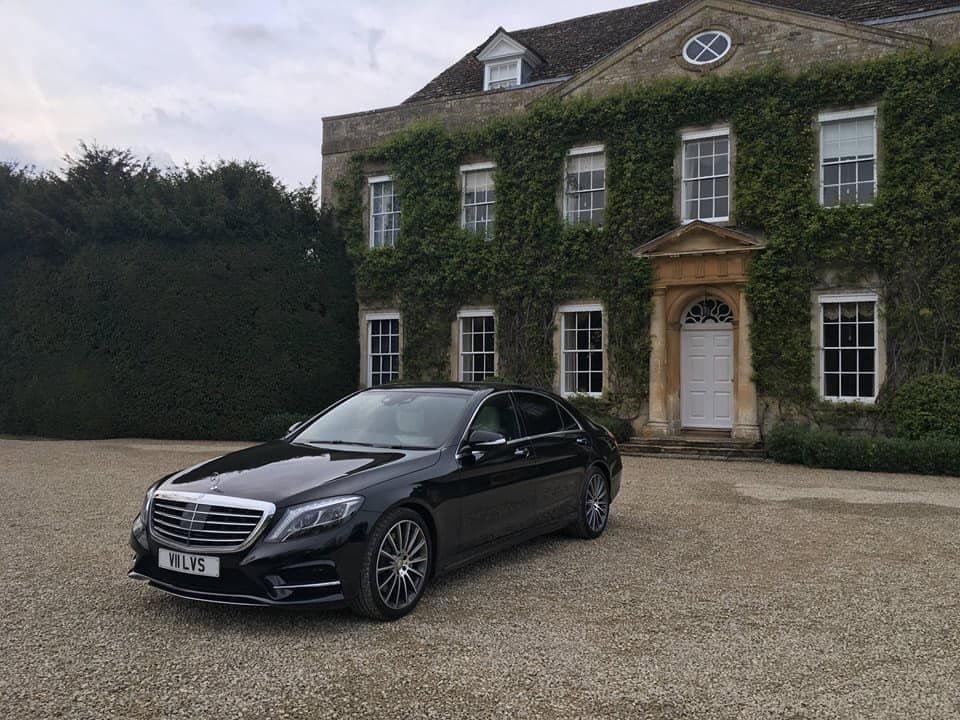 Mercedes-Benz S-Class chauffeur car waiting in front of a luxury house for a corporate client