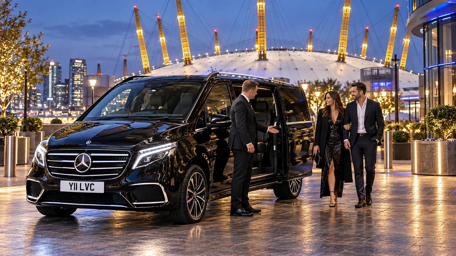 Illustration of a chauffeur welcoming guests beside a black Mercedes-Benz V-Class with the illuminated O2 arena behind them