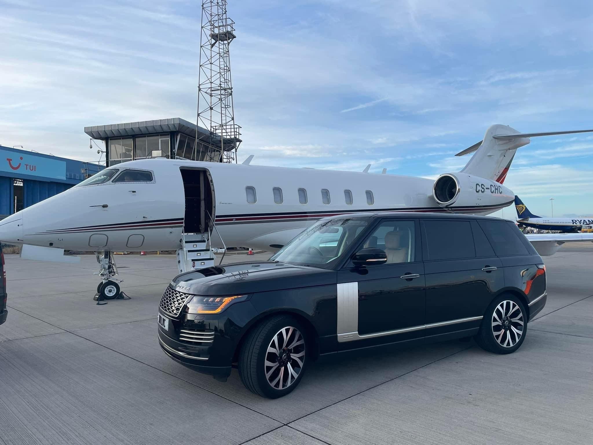 Luxury chauffeur SUV parked beside a private jet at Farnborough FBO
