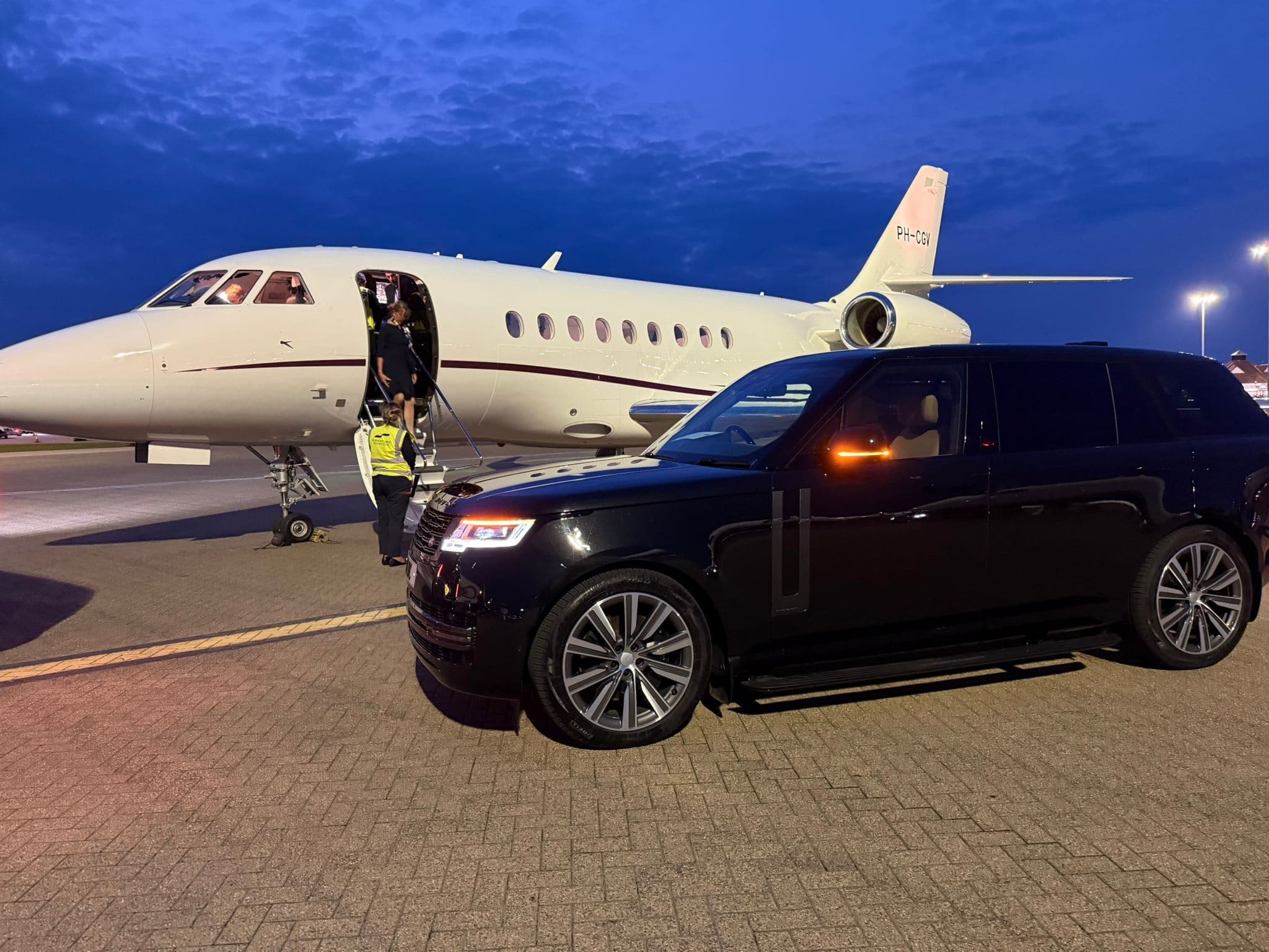 SUV collecting passengers from a private jet at Farnborough tarmac