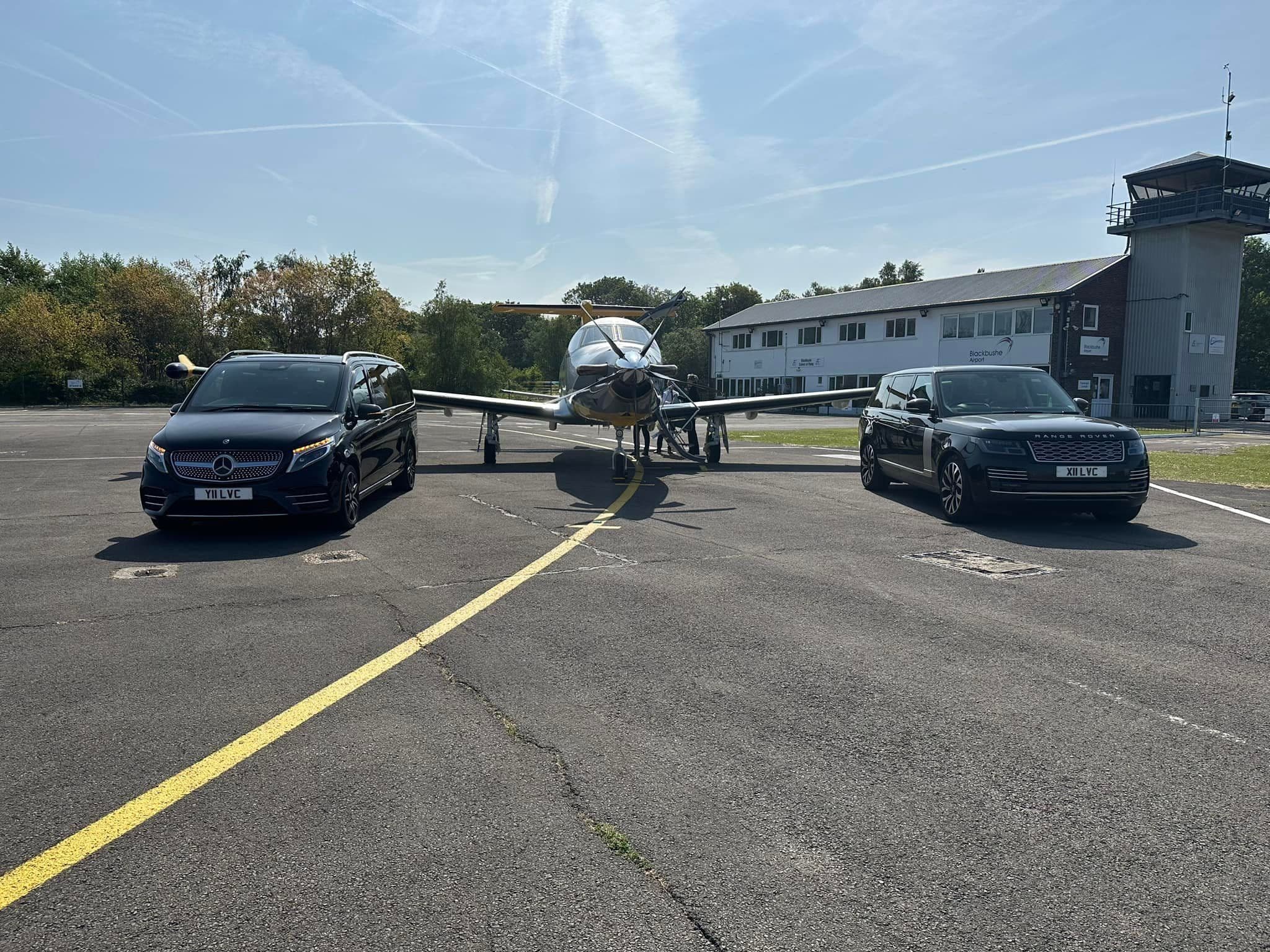 Luxury SUV and Mercedes V-Class parked near a private jet for VIP chauffeur service