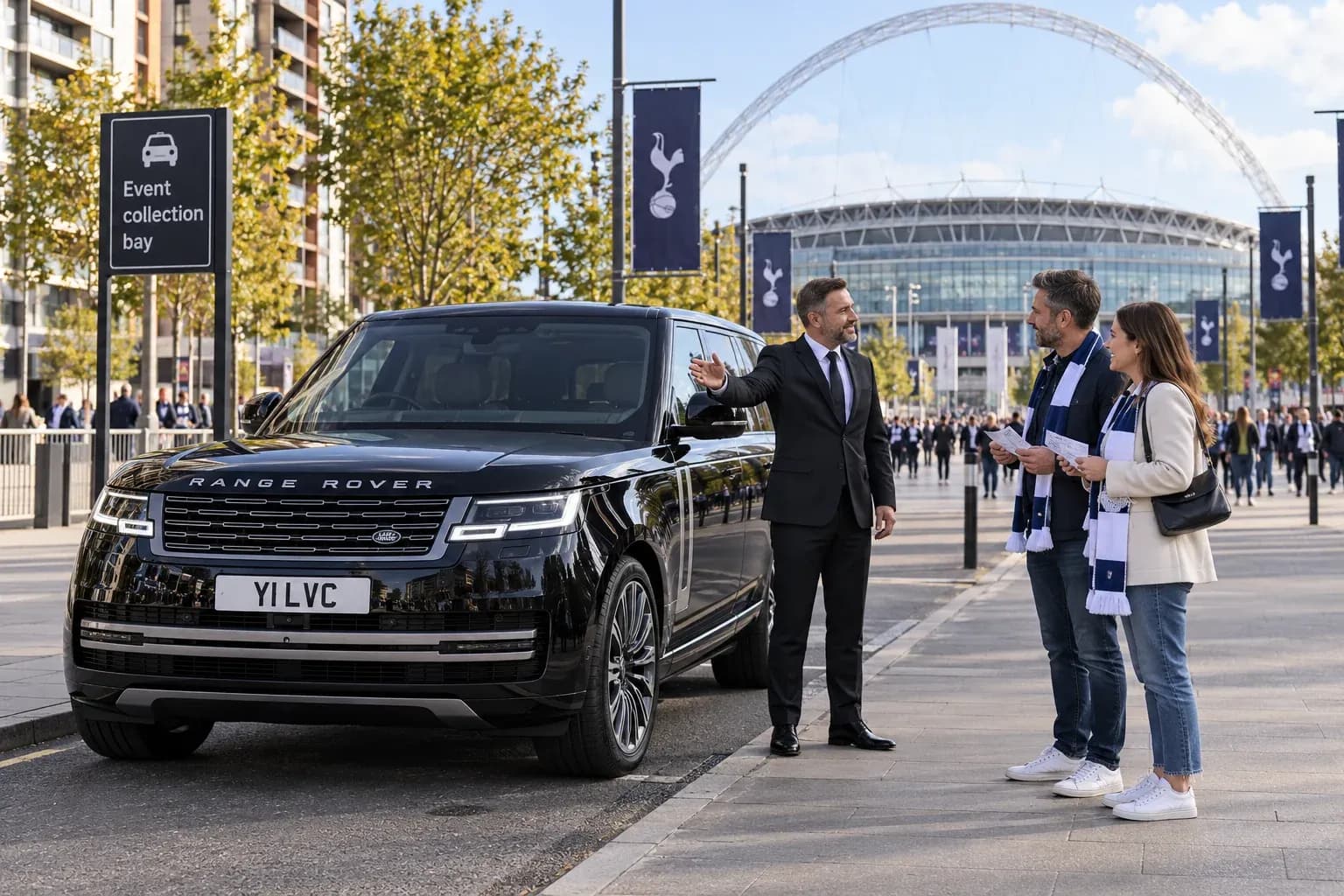 Chauffeur explaining a Wembley collection point beside a Range Rover.